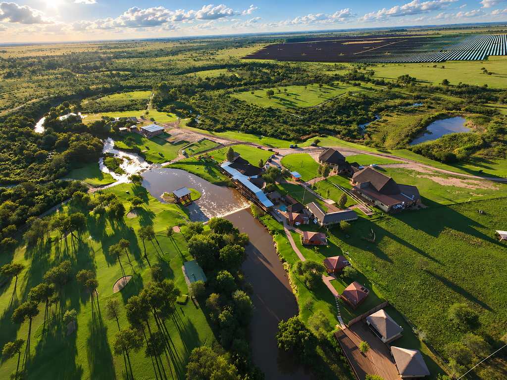 The Doring River winding past the lawns and buildings of the ranch, seen from above.