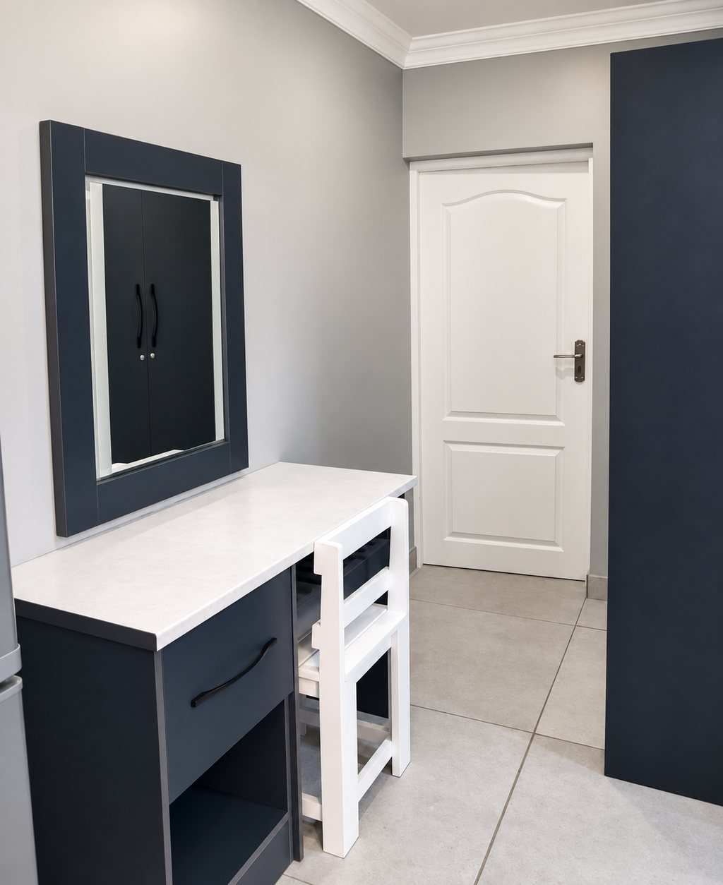 The desk and mirror in a Family Room, with the panelled door through to the second bedroom.