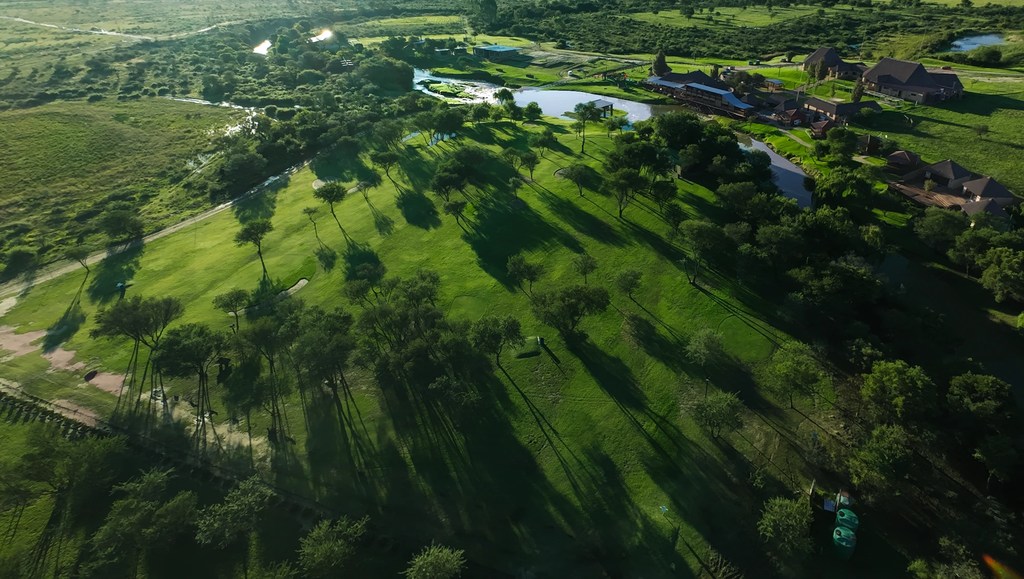 An aerial view across the Goldfields golf course in the early morning, with the river and the ranch buildings beyond.