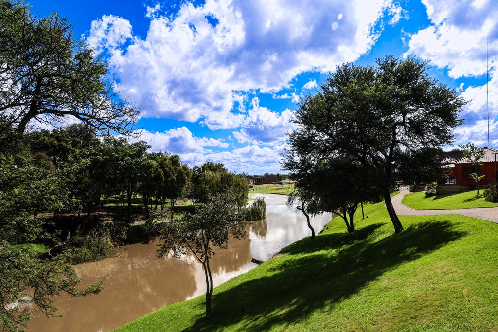 The Doring River winding past thatched trees and mown lawns at Goldfields Game Ranch.