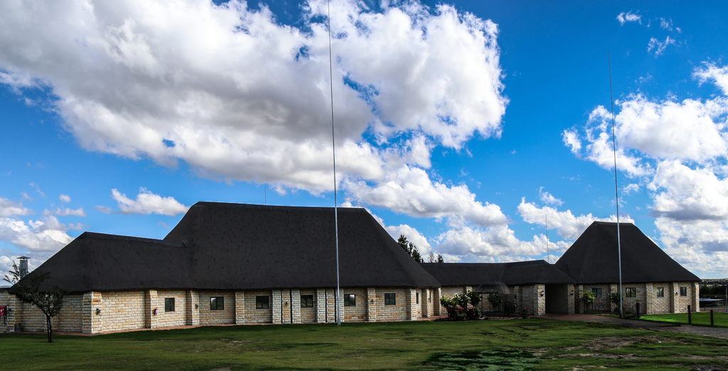 The thatched stone function venue at Goldfields Game Ranch under a wide Free State sky.
