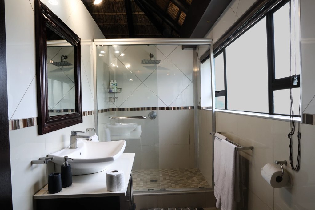 The glass shower and vanity in the Honeymoon Suite bathroom, lit by a frosted window.