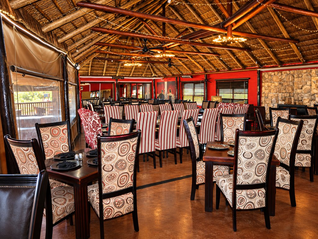 Laid tables and patterned upholstered chairs in the indoor dining room at the Goldfields restaurant.