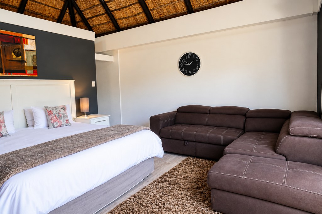 A Sandstone Room with a television, wardrobe and dressing table, and sliding doors onto the deck.