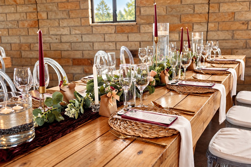 A long candlelit table laid for a reception inside the sandstone hall.