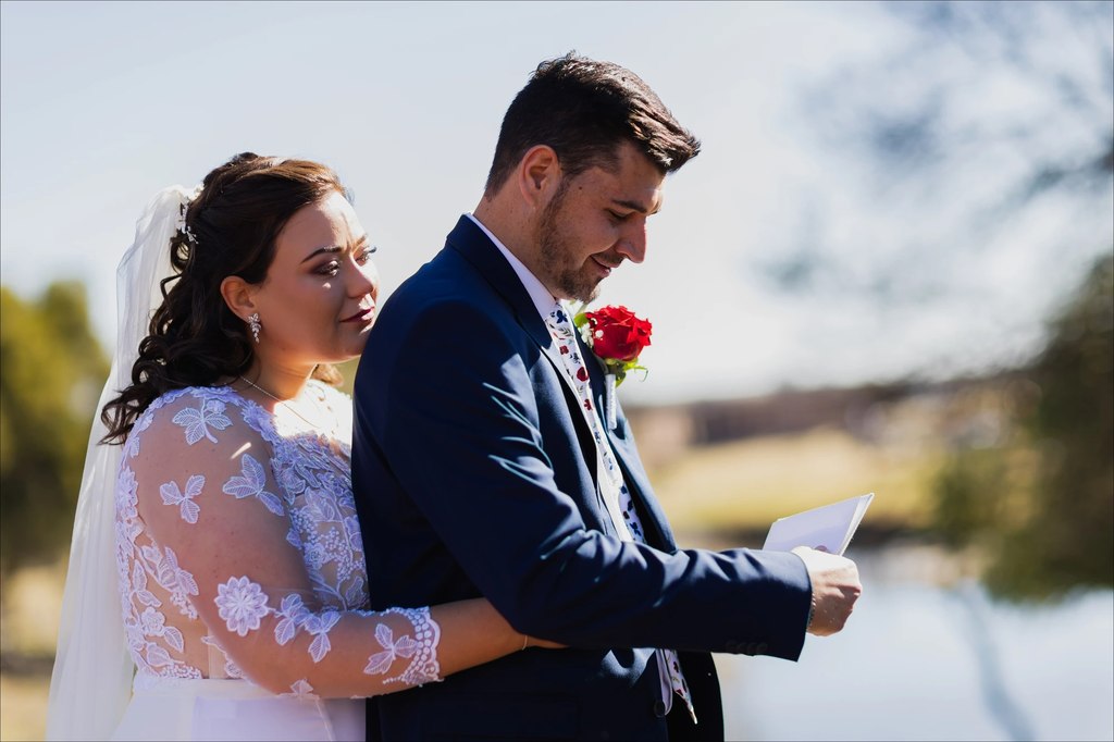 A bride and groom holding each other while he reads his letter aloud at Goldfields Game Ranch.