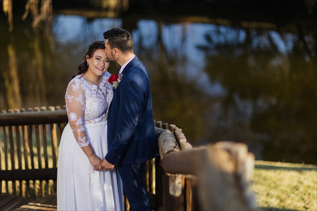 A groom kissing the bride on the forehead on the timber deck at Goldfields Game Ranch.