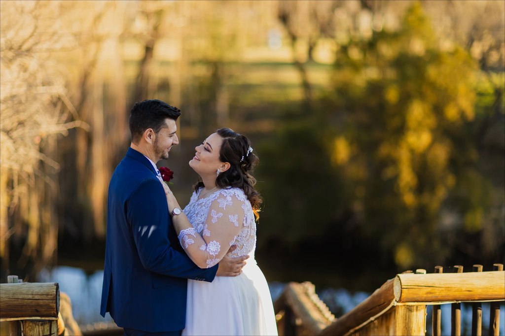 A bride and groom embracing on the deck with backlit willows behind them at Goldfields Game Ranch.